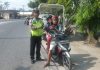 Personil Sat Lantas Polres Tanjung Balai bagi bagi cokelat dan bunga ke pengendara bermotor
