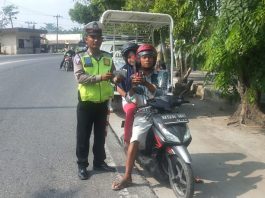 Personil Sat Lantas Polres Tanjung Balai bagi bagi cokelat dan bunga ke pengendara bermotor