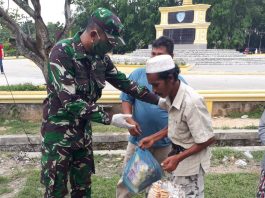 Komandan Kompi Senapan C Yonif 126/KC Lettu Inf Tommy Marselino memberitan paket sembako kepada warga (Foto: ist)
