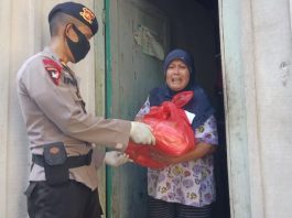 Salah seorang warga merasa terharu saat mendapatkan bantuan dari personel Sat Brimob Polda Sumut. (Foto: istimewa)