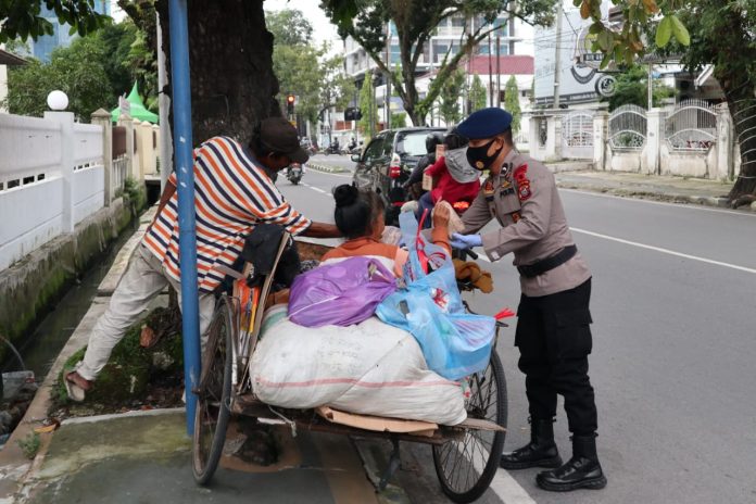 IMG-20200518-WA0133 Personil Sat Brimob Polda Sumut bagikan nasi bungkus kepada warga yang sedang menaikin becak barang di Jl. Wahid Hasyim Medan
