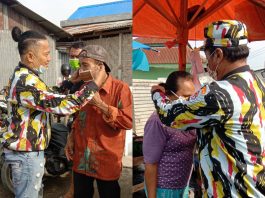Ketua DPC PKN Deli Serdang Tumpal Sijabat terlihat memakaikan masker terhadap salah satu pedagang di TPI Pantai Labu, Sabtu (12/6/2021)